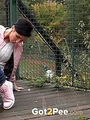 15 pictures - Dark haired girl squats to piss on decking