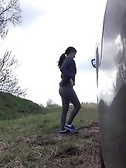 15 pictures - Shy teen pisses behind a parked car on the grass