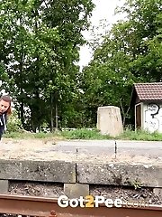 15 pictures - Sexy brunette pisses over the train tracks