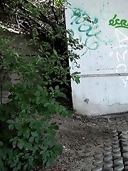 15 pictures - Sexy brunette pisses in the city on drain pipe