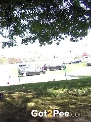 15 pictures - Dark haired woman is filmed pissing by a tree