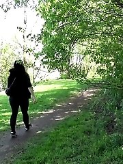 15 pictures - Dark haired woman is filmed pissing by a tree