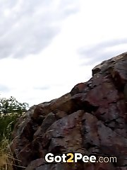 15 pictures - Sexy blonde enjoys a pee standing on rocks