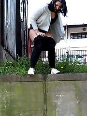 15 pictures - Dark haired girl sprinkles her piss off a ledge