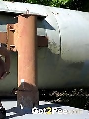 15 pictures - Busty brunette pissing on an industrial area
