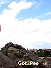 15 pictures - Sexy blonde enjoys a pee standing on rocks