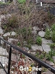 15 pictures - Sexy brunette babe pisses in public on some steps