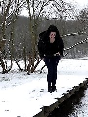 15 pictures - Dark haired girl pees on a bridge in the snow