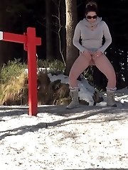 15 pictures - Pretty brunette lifts up her skirt to piss in the snow