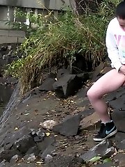 15 pictures - Dark haired girl pisses next to a flowing river