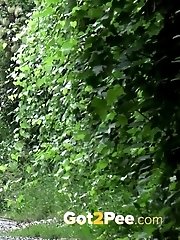 15 pictures - Pretty redhead pisses outside while standing