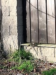 15 pictures - Brunette pees as she leans on a wall