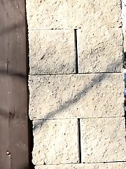 15 pictures - Brunette pees as she leans on a wall