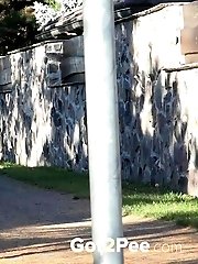 15 pictures - Brunette pees as she leans on a wall