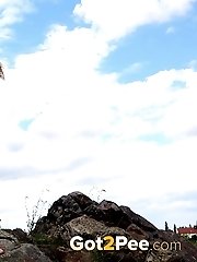 15 pictures - Sexy blonde enjoys a pee standing on rocks