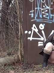 15 pictures - Brunette girl pulls down her trousers to pee outside