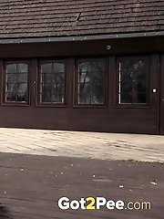 15 pictures - Brunette in glasses pisses on wooden decking