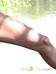 15 pictures - Blonde pissing over a tree near the river